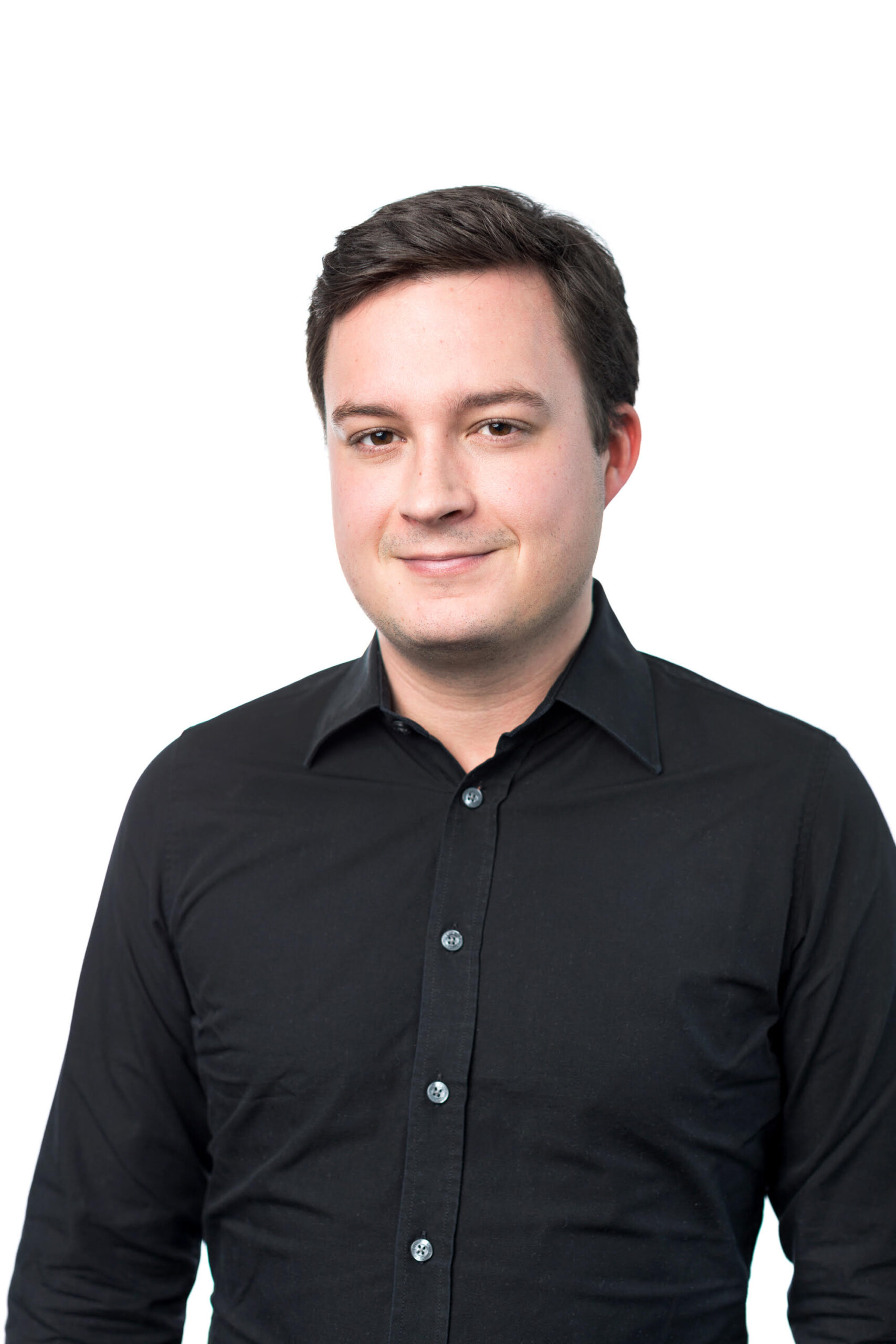 Mann mit schwarzem Hemd und braunen Haaren, der grinst